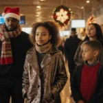 Travelers standing together in an airport terminal with holiday decorations and a sparkly scarf catching the golden light