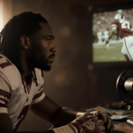 Jalen Hurts studying footage from college football days with worn-out gloves and faded jersey in background.