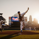 Brad Keller pitching a fastball with Phillies logo shining behind and Philadelphia skyline glowing at sunset