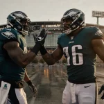 Eagles linemen Landon Dickerson and Fred Johnson high‑fiving with stadium lights glowing in light and Commanders logo hints.