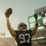 Dallas Goedert raising football with triumphant pose and bright Raiders scoreboard.