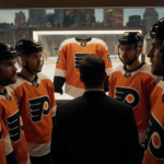 Flyers players huddle with empty jersey display and a coach in dim warm light