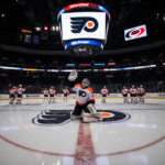 Goalie Ilya Sorokin kneeling with glove raised in defeat while Carolina players celebrate the shootout win on the hockey rink