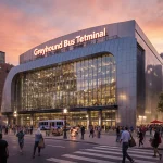 Greyhound Bus Terminal gleams with glass facade under orange sunset and bustling crowds on the surrounding streets