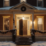 Front door ajar with golden light and snowy Chicago backdrop festive holiday decorations visible on porch