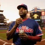 Jimmy Rollins standing at home plate holding his World Series ring with Phillies City Hall shining in evening light