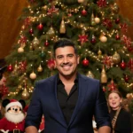 Luis Fonsi sings to guests with a sparkling Christmas tree and candles in the background.