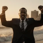 Atlantic City mayor Marty Small raising his arms with tears in sunset glow and ocean waves crashing behind him and courtroom