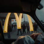 Golden arches reflecting in car glass with faint light from ajar McDonald