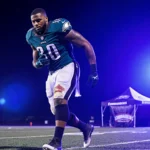 Nakobe Dean hobbling off the football field with an injured hamstring and the Eagles logo on his jersey