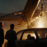 Small plane plummeting onto a car with sparks flying during emergency landing and a shocked father and son watching nearby