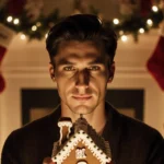 Timothée Chalamet holding a gingerbread house ornament with Kardashian‑Jenner logo with warm glow and garlands background