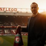 Tom Hicks standing in front of a soccer stadium with Liverpool