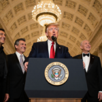 President Donald Trump standing at podium with Sylvester Stallone Paul Simon and Barbra Streisand near Kennedy lobby.