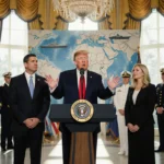 President Trump speaking at podium with Senator Rubio and Governor Hegseth beside him and navy officers nearby Venezuelan map
