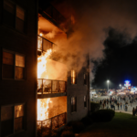 Fire burns Wildwood apartment building with orange flames licking balcony railing and smoke swirling over Jersey Shore boardw