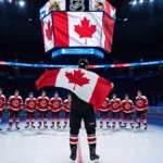 Sidney Crosby standing proud with Canadian flag draped over his shoulder and Connor McDavid behind him in a hockey team ice r