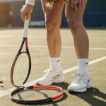 Coco Gauff stands with shattered racquet at her feet and golden light across grassy tennis court after loss.