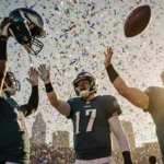 Brandon Johnson holds up his helmet with confetti and a Philadelphia skyline backdrop as Eagles celebrate victory.
