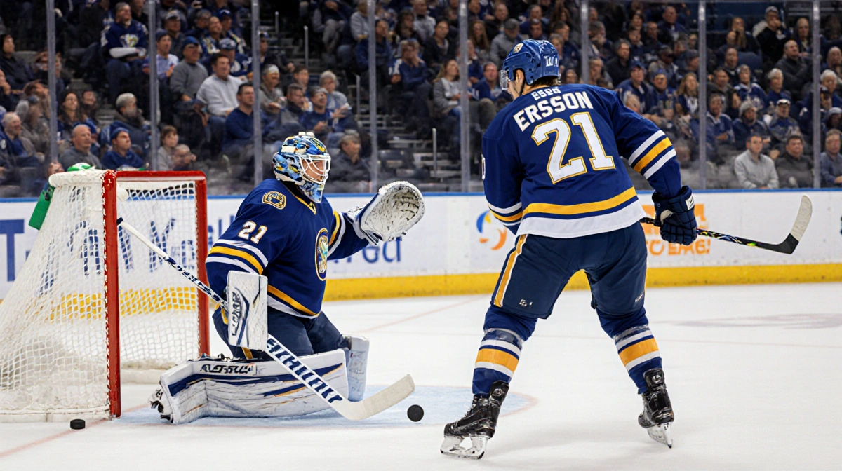 Goalie standing with back to camera while teammate approaches crease and puck slides toward empty net