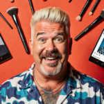 Guy Fieri laughing at his new makeover with bright backdrop and scattered makeup tools from viral Instagram video and trendy
