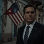 Secretary Rubio standing before a faded American flag with dimly lit Havana street and crumbling building in background
