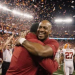 Hoosiers fans celebrate Indiana football championship with confetti and coach Woodson embracing players while Miami players e