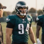 Lane Johnson stands confidently with teammates on Philadelphia Eagles practice field watching Coach Nick Sirianni