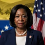 Rep. Marjorie Taylor Greene stands looking straight with American flag behind her and Venezuelan flag in shadow politics.