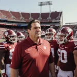 Mark Cuban stands with Indiana University football team and national championship trophy on sidelines