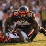 Myles Garrett wrapping Joe Burrow in a record‑breaking sack with golden hour glow on helmet and crowd cheering