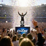 NASCAR driver celebrating victory with arms raised and confetti falling with packed stadium and championship trophy behind