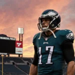 Philadelphia Eagles player stands alone under stadium scoreboard with sunset sky showing determination and empty seats