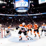 Barkey scores first career goal with puck past Oilers goalie while confetti explodes above scoreboard 5-2.