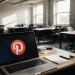Laptop screen displays Pinterest logo with long shadows across deserted office.