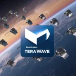 Silver satellites orbit Earth in hexagonal formation with glowing trails and Blue Origin TeraWave logo floating over sunset s