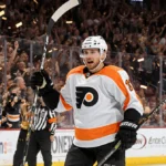 Travis Konecny celebrates his game-winning goal with stick raised high and stunned Vegas players behind him