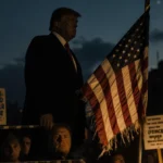 Frayed American flag waves at dusk with Trump